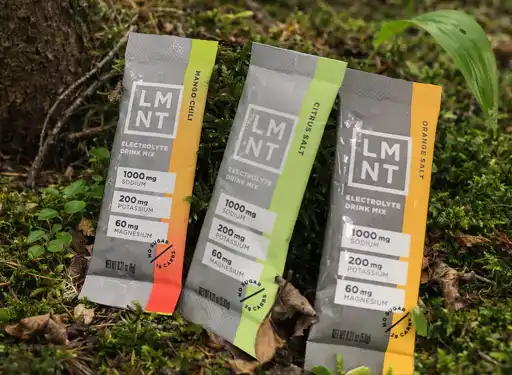 A display of LMNT electrolyte packets on a forest floor