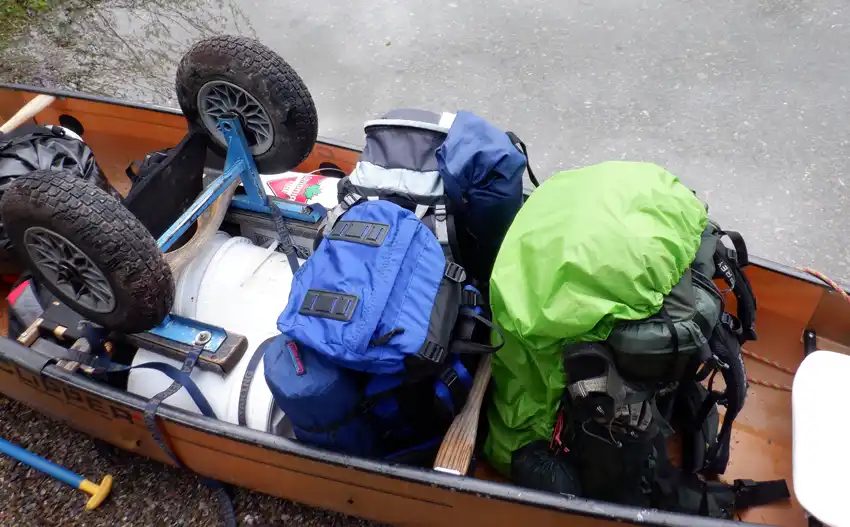 A close up of camping gear and food pails in a canoe