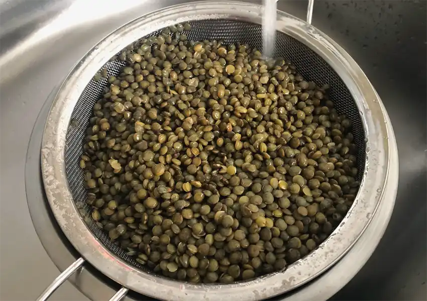 Running cold water on the lentils to stop cooking