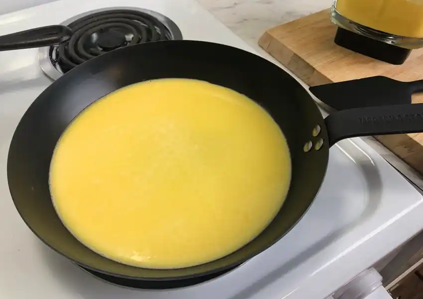 View of blended eggs in a frypan on the stove