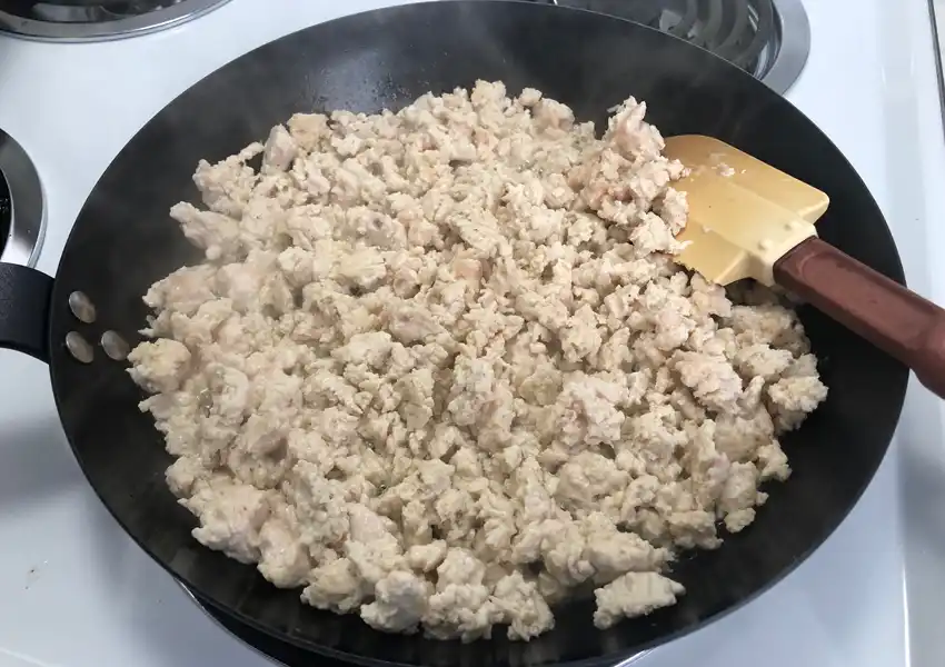 Cooling ground chicken in a fry pan on the stove